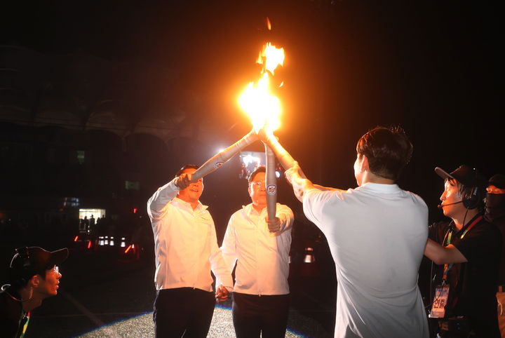 [순창=뉴시스] 김종효 기자 = 지난 6일 순창공설운동장에서 열린 제61회 전북특별자치도민체육대회 개막식, 전북특별자치도 최병관 행정부지사(뒤 오른쪽)와 최영일 순창군수(뒤 왼쪽)가 성화대 점화자인 역도 국가대표 유동준 선수에게 성화를 전달하고 있다. (사진= 순창군 제공) 2024.09.07. photo@newsis.com  *재판매 및 DB 금지