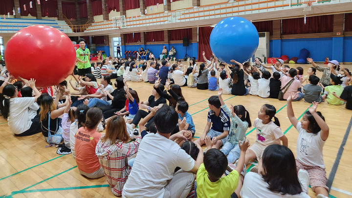 [서산=뉴시스] 지난 7일 서산중앙고등학교 체육관에서 열린 2024년 드림스타트 가족 운동회에 참가한 가족들이 큰 공 굴리기를 하고 있다. (사진=서산시 제공) 2024.09.08.  *재판매 및 DB 금지