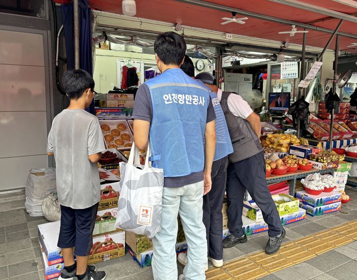 [인천=뉴시스] 저소득 가정 아동과 함께 전통시장에서 장을 보고 있다. (사진=인천항만공사 제공)  *재판매 및 DB 금지