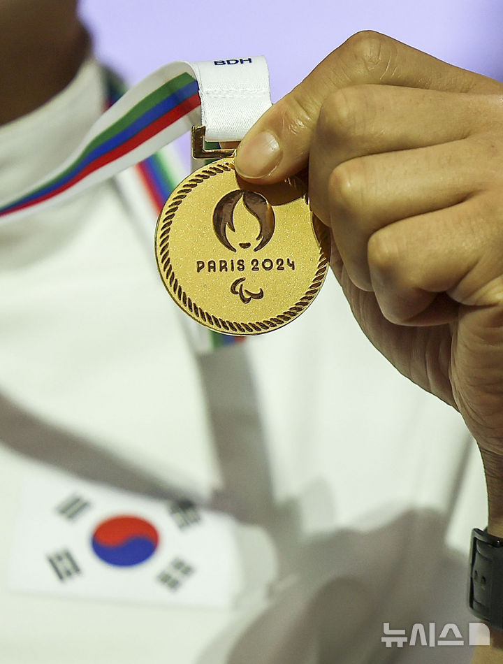 [인천공항=뉴시스] 정병혁 기자 = 10일 인천국제공항 제2여객터미널에서 열린 2024 파리패럴림픽 대회 대한민국 선수단 해단식에서 선수가 순금 메달을 들고 있다. 2024.09.10. jhope@newsis.com