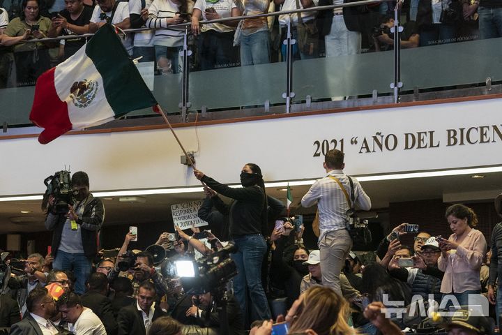 Protesters interrupt a Senate session in which lawmakers were debating the government's proposed judicial reform, which would make judges stand for election, in Mexico City, Tuesday, Sept. 10, 2024. (AP Photo/Felix Marquez)