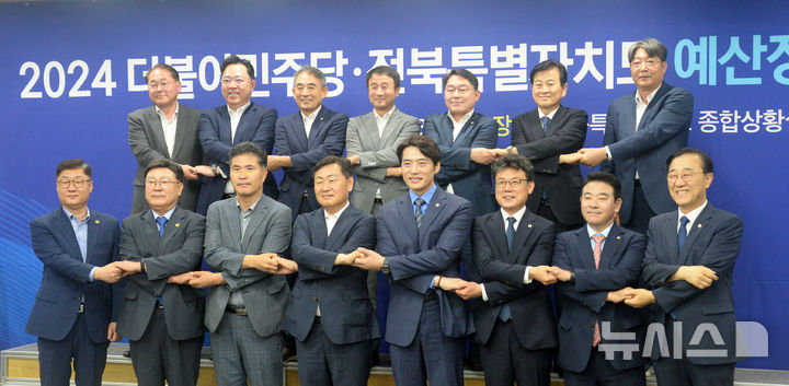 [전주=뉴시스] 김얼 기자 = 김관영 전북특별자치도지사와 한준호 더불어민주당 최고위원을 비롯한 관계자들이 11일 전북 전주시 전북특별자치도청에서 열린 '2024 더불어민주당·전북특별자치도 예산정책협의회'에 참석해 손을 맞잡고 기념촬영을 하고 있다. 2024.09.11. pmkeul@newsis.com