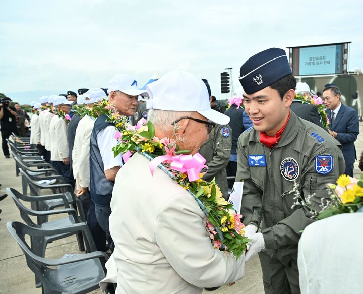 [서울=뉴시스] 13일 공군 강릉기지 주기장에서 열린 '공군작전 전승기념행사'에서 공군 조종사들이 국가유공자들에 꽃목걸이를 걸어드리고 있다. (사진=공군 제공) 2024.09.13. photo@newsis.com *재판매 및 DB 금지