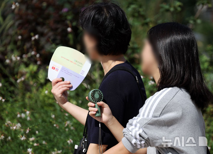 [서울=뉴시스] 홍효식 기자 = 서울 전 지역에 폭염주의보가 발령된 15일 서울 중구 서울시청 인근에서 시민들이 부채와 손 선풍기를 들고 더위를 식히고 있다. 2024.09.15. yesphoto@newsis.com