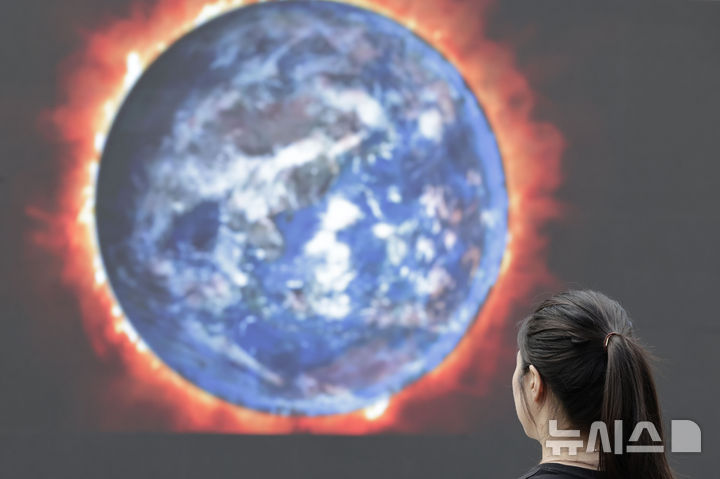 [서울=뉴시스] 최동준 기자 = 지난해 9월 19일 서울 서대문구 유플렉스 앞 스타광장에서 그린피스 서울사무소가 GDP 맹신의 부작용을 알리는 퍼포먼스를 위해 설치한 전광판에 뜨거운 지구를 묘사한 화면이 나오고 있다. 2024.09.19. photocdj@newsis.com