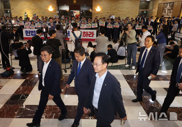 [서울=뉴시스] 고승민 기자 = 더불어민주당 의원들이 19일 서울 여의도 국회에서 열린 제418회 국회(정기회) 제8차 본회의에 참석하고 있다.  이들 뒤로 국민의힘 의원들이 입법 폭주 및 포퓰리즘 규탄 등의 피켓을 들고 구호를 외치고 있다.  2024.09.12. kkssmm99@newsis.com