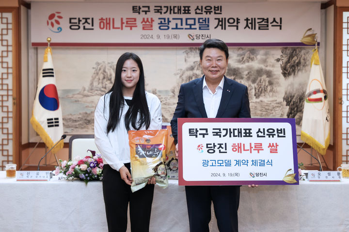 [당진=뉴시스] 지난 19일 당진시청 3층 해나루홀에서 올림픽 탁구 국가대표 신유빈 선수(왼쪽)가 당진 해나루쌀 광고 모델 계약을 체결한 후 오성환 시장과 함께 협약서를 들고 기념 촬영을 하고 있다. (사진=당진시 제공) 2024.09.20. *재판매 및 DB 금지