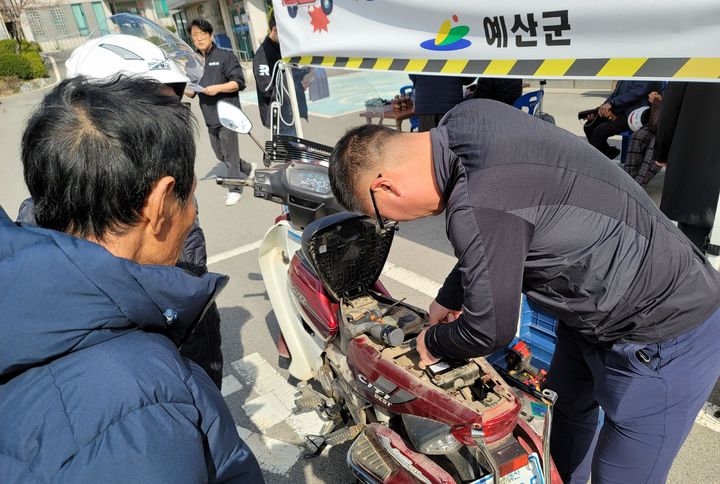 [서울=뉴시스] 한국교통안전공단과 충남 예산군이 고령운전자의 이륜차에 사고자동신고 장치를 설치하는 모습. 2024.09.20. (사진=교통안전공단 제공) photo@newsis.com  *재판매 및 DB 금지