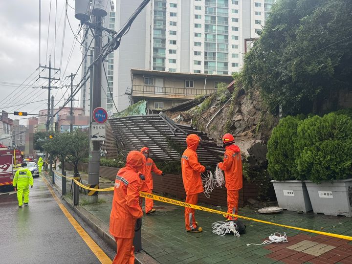 [부산=뉴시스] 권태완 기자 = 지난 21일 오전 호우경보가 발효된 부산 사상구 학장동의 한 건물 벽이 집중호우로 인해 무너졌다는 신고가 접수돼 출동한 소방과 경찰이 인근 도로를 통제하고 있다. (사진=부산소방재난본부 제공) 2024.09.21. photo@newsis.com *재판매 및 DB 금지