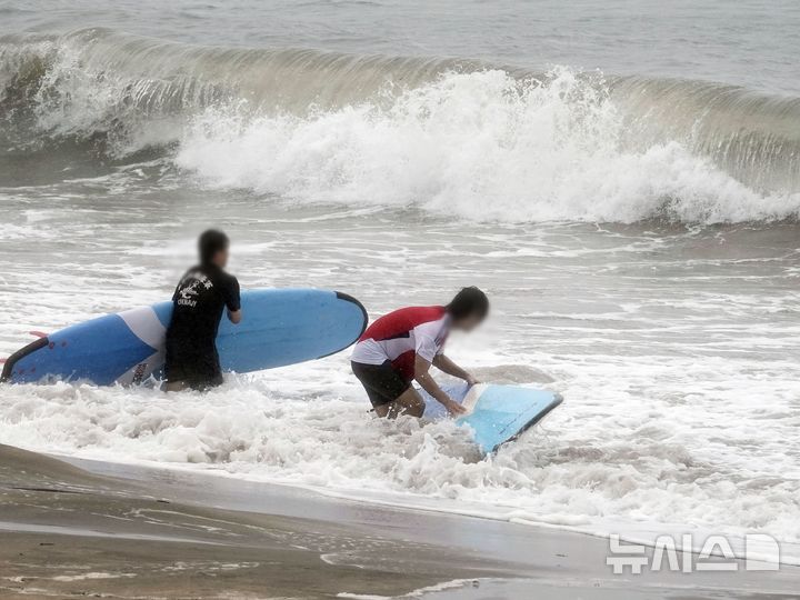 [제주=뉴시스] 오영재 기자 = 풍랑주의보가 발효 중인 22일 제주시 이호테우해수욕장에서 서핑객들이 보드를 들고 바다로 나가고 있다. 2024.09.22. oyj4343@newsis.com