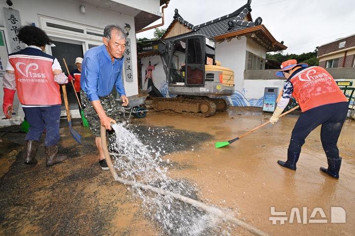 [해남=뉴시스] 이영주 기자 =전남 해남군 문내면 충무마을에서 주민과 자원봉사자가 흙탕물을 씻어내고 있다. 해남에는 지난달 21일 오후 시간당 최대 101㎜ 폭우가 내려 문내면 등 마을 곳곳이 침수되는 피해를 입었다. 2024.09.22. leeyj2578@newsis.com