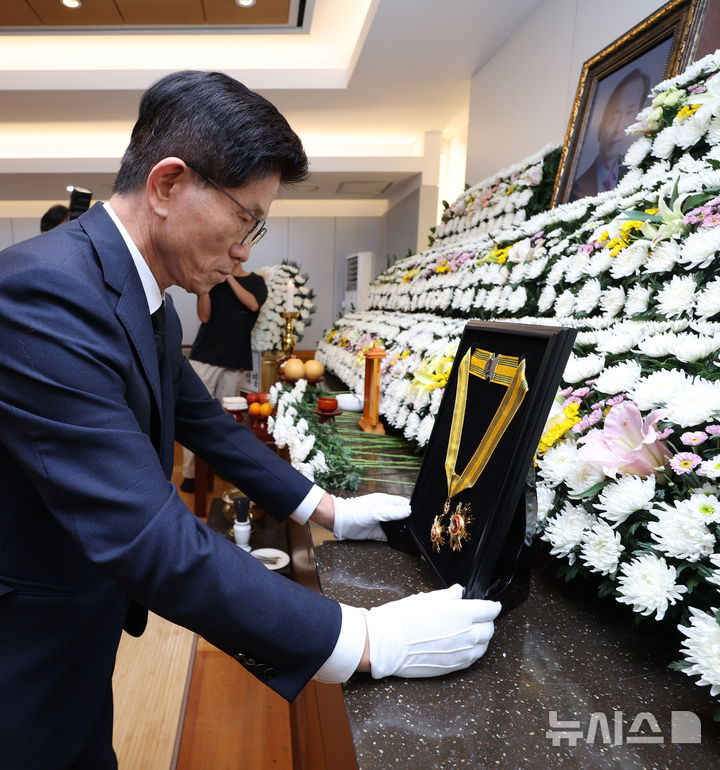 [서울=뉴시스] 정병혁 기자 = 김문수 고용노동부 장관이 22일 서울 종로구 서울대학교병원 장례식장에 마련된 고 장기표 신문명정책연구원 원장 빈소에서 국민훈장 모란장을 추서하고 있다. (공동취재) 2024.09.22. photo@newsis.com