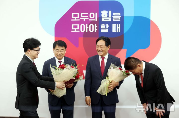 [서울=뉴시스] 조성봉 기자 = 한동훈 국민의힘 대표가 23일 오전 서울 여의도 국회에서 열린 10.16 재보궐선거 후보자 추천장 수여식에서 후보자들에게 꽃다발을 전달하고 있다. 왼쪽부터 한 대표, 윤일현 부산 금정구청장 후보,박용철 인천 강화군수 후보자, 최봉의 전남 곡성군수 후보. 2024.09.23. suncho21@newsis.com