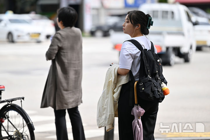 [광주=뉴시스] 이영주 기자 = 광주지역 일교차가 10도 이상으로 예보된 지난 23일 오전 광주 북구청 사거리에서 한 시민이 겉옷을 챙긴 채 횡단보도 신호를 기다리고 있다. 2024.09.23. leeyj2578@newsis.com