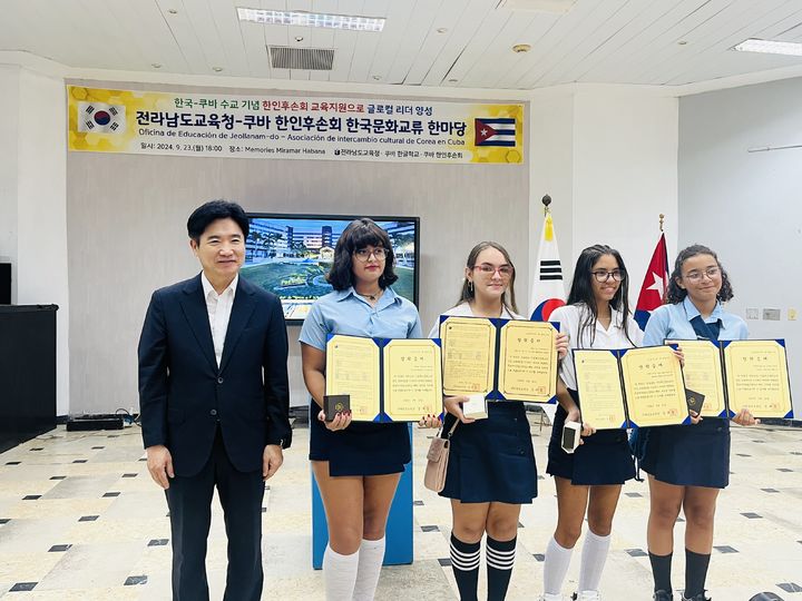 [무안=뉴시스] 지난 23일 쿠바 메모리즈 미라마 아바나 호텔에서 김대중 전남교육감과 쿠바 한인 후손 초청 장학생들이 장학증서와 함께 기념촬영 하고 있다. (사진 = 전남교육청 제공). 2024.09.24. photo@newsis.com *재판매 및 DB 금지