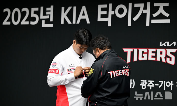 [광주=뉴시스] 김혜인 기자 = 2025년 KIA 타이거즈 신인 선수 입단식이 열린 24일 오후 광주 북구 기아챔피언스필드에서 최준영 대표이사가 김태형 선수에게 기아타이거즈 유니폼을 입혀주고 있다. 2024.09.24. hyein0342@newsis.com