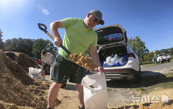[올랜도( 미 플로리다주)=AP/뉴시스] 미국 플로리다주에 허리케인으로 상륙할 열대성폭풍 헬렌에 대비해서 플로리다주 올랜도 시내에서는 9월 24일(현지시간) 주민들이 모래주머니를 만드는 작업에 나섰다.&nbsp; 허리케인 헬렌은 3급 허리케인의 위력으로 멕시코만 일대를 강타할 것으로 예보되었다. 2024 09.25.