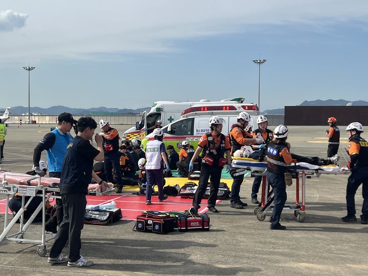 [서울=뉴시스] 26일 김해공항에서 이뤄진 재난대응 안전한국훈련 시범훈련 과정에서 자체소방대 초동 대응 및 응급환자를 이송하는 모습. 2024.09.26. (사진=한국공항공사 제공) photo@newsis.com  *재판매 및 DB 금지