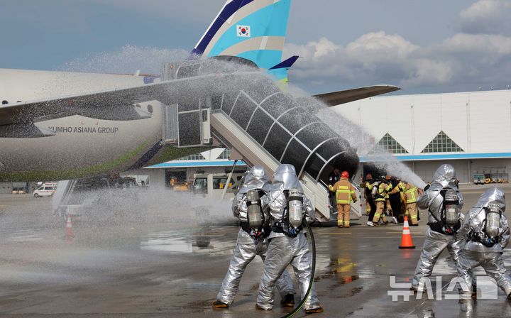 [부산=뉴시스] 하경민 기자 = '2024 재난대응 안전한국훈련 김해국제공항 항공기 사고수습 종합훈련'이 열린 26일 부산 강서구 김해국제공항에서 소방대원들이 항공기끼리 충돌사고를 가정한 화재를 진압하면서 부상 승객을 구조하고 있다.   이번 훈련에는 한국공항공사, 군, 경찰, 소방 등 31개 기관에서 250여 명이 참여했다. 2024.09.26. yulnetphoto@newsis.com