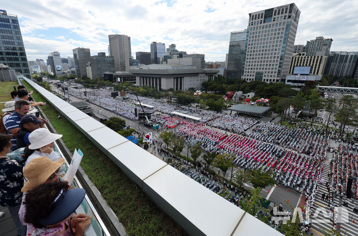 [서울=뉴시스] 김금보 기자 = 28일 서울 종로구 대한민국역사박물관 옥상정원에서 시민들이 '2024 국제선명상대회(불교도대법회)' 국민오계 수계법회가 열리고 있는 광화문광장을 내려다보고 있다. 2024.09.28. kgb@newsis.com