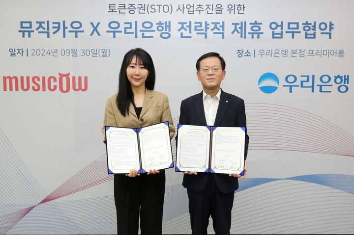 지난달 30일 우리은행 본점에서 조병규 은행장(오른쪽)이 뮤직카우 정현경 대표이사와 업무협약을 체결하고 있다. (사진=우리은행 제공) *재판매 및 DB 금지