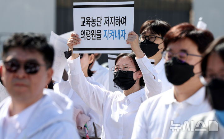 [서울=뉴시스] 추상철 기자 = 3일 오후 서울 용산구 대통령실 앞에서 열린 '의학교육평가원 무력화 저지를 위한 전국의과대학 교수 결의대회'에서 참가자가 피켓을 들고 있다. 2024.10.03. scchoo@newsis.com