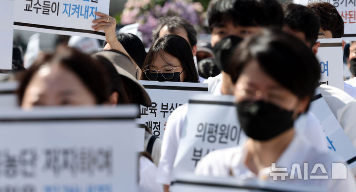 [서울=뉴시스] 추상철 기자 = 3일 오후 서울 용산구 대통령실 앞에서 열린 '의학교육평가원 무력화 저지를 위한 전국의과대학 교수 결의대회'에서 참가자들이 피켓을 들고 있다. 2024.10.03. scchoo@newsis.com