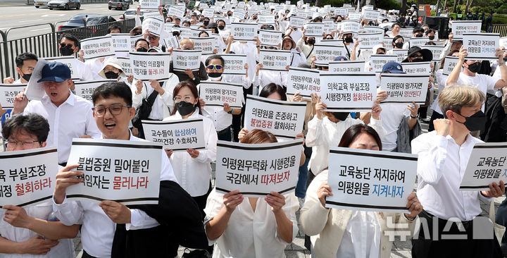 [서울=뉴시스] 추상철 기자 = 3일 오후 서울 용산구 대통령실 앞에서 열린 '의학교육평가원 무력화 저지를 위한 전국의과대학 교수 결의대회'에서 참가자들이 구호를 외치고 있다. 2024.10.03. scchoo@newsis.com