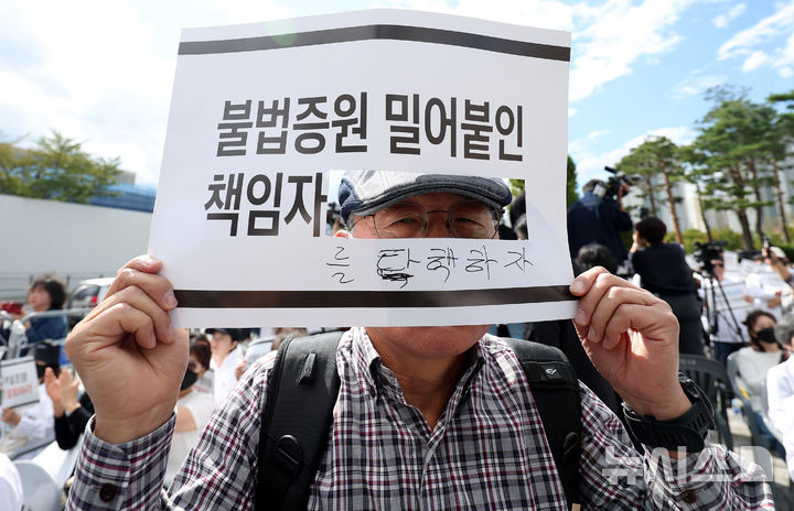 [서울=뉴시스] 추상철 기자 = 3일 오후 서울 용산구 대통령실 앞에서 열린 '의학교육평가원 무력화 저지를 위한 전국의과대학 교수 결의대회'에서 의대 원로교수가 피켓을 들고 있다. 2024.10.03. scchoo@newsis.com