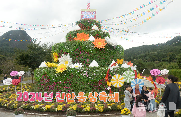 [진안=뉴시스] 김얼 기자 = 2024 진안 홍삼축제가 개막한 3일 전북 진안군 마이산 북부 특설무대를 찾은 시민들이 꽃 조형물 앞에서 사진을 찍고 있다. 2024.10.03. pmkeul@newsis.com