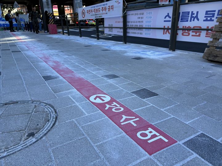 [서울=뉴시스] 우지은 기자 = 4일 오전 인부 2명이 서울 지하철 성수역 3번출구 앞 인도에 색깔블록을 설치하고 있다. 2024.10.04. now@newsis.com *재판매 및 DB 금지