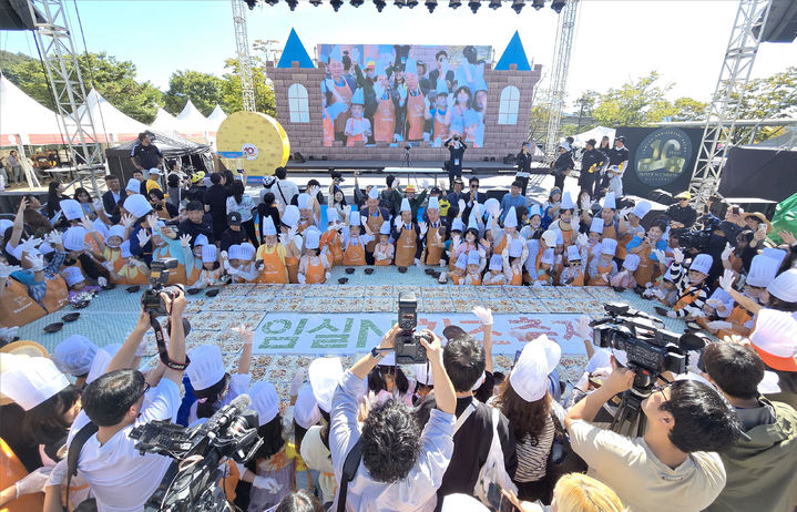 [임실=뉴시스] 김종효 기자 = '2024 임실N치즈축제' 개막 이틀째인 4일, 많은 관광객들이 한데 모여 대형 피자만들기에 도전하고 있다. (사진=임실군청 제공) 2024.10.04. photo@newsis.com  *재판매 및 DB 금지