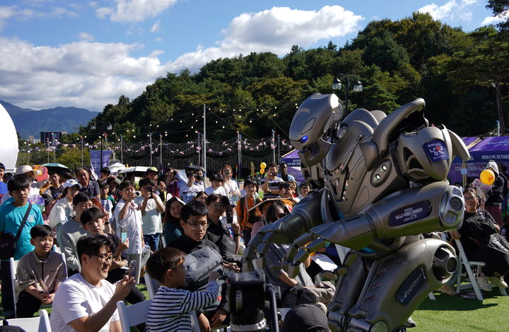 [남원=뉴시스] 김종효 기자 = '2024 남원 국제드론제전 with 로봇'이 개막 이틀째인 4일, 인간형 로봇 타이탄이 한 어린이와 악수를 하기 위해 손을 내밀고 있다. (사진=남원시청 제공) 2024.10.06. photo@newsis.com *재판매 및 DB 금지
