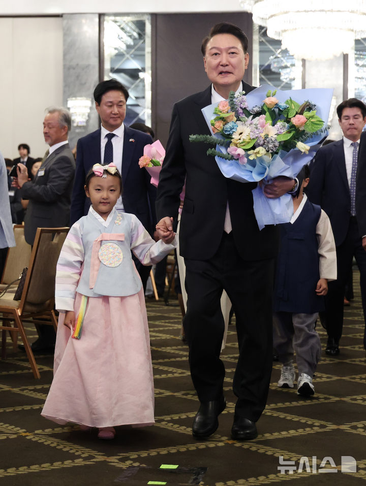 [마닐라=뉴시스] 최진석 기자 = 필리핀을 국빈 방문한 윤석열 대통령이 6일(현지시각) 마닐라 페닌슐라호텔에서 열린 필리핀 동포 초청 만찬 간담회에 입장하며 화동으로부터 꽃을 받은 뒤 함께 이동하고 있다. 2024.10.06. myjs@newsis.com