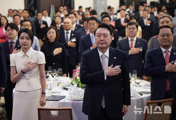 [마닐라=뉴시스] 최진석 기자 = 필리핀을 국빈 방문한 윤석열 대통령과 부인 김건희 여사가 6일(현지시각) 마닐라 페닌슐라호텔에서 열린 필리핀 동포 초청 만찬 간담회에서 국기에 경례하고 있다. 2024.10.06. myjs@newsis.com