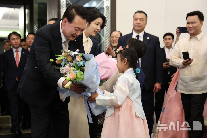 [마닐라=뉴시스] 최진석 기자 = 필리핀을 국빈 방문한 윤석열 대통령과 부인 김건희 여사가 6일(현지시각) 마닐라 페닌슐라호텔에서 열린 필리핀 동포 초청 만찬 간담회에 입장하며 화동으로부터 꽃을 받고 있다. 2024.10.06. myjs@newsis.com