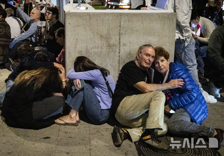 [ 텔아비브=신화/뉴시스] 10월 7일 가자전쟁 시작 1주년이 되는 날 이스라엘 중부 텔아비브시에 대한 헤즈볼라의 공습으로 사이렌 경보에 따라 몸을 피하고 있는 시민들 2024.10.08. 