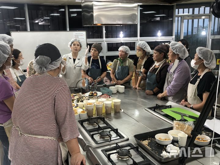 [여주=뉴시스]오곡나루축제 대표 먹거리에 대해 설명을 듣고 있다(사진제공=여줏시)