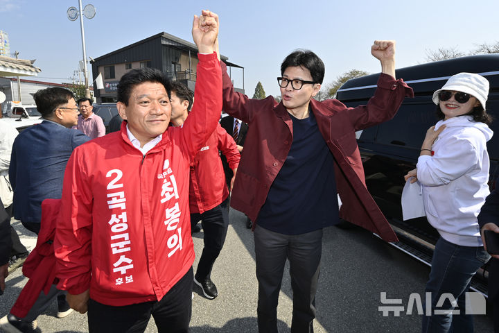 [곡성=뉴시스] 박기웅 기자 = 한동훈 국민의힘 대표가 8일 오전 전남 곡성군 기차마을 전통시장을 방문해 10·16 재보궐선거 곡성군수에 출마한 최봉의 후보의 손을 들어올리고 있다. 2024.10.08. pboxer@newsis.com