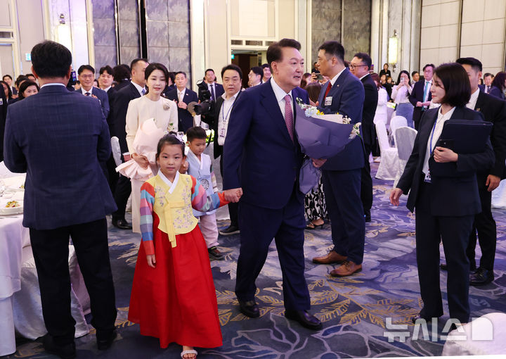 [싱가포르=뉴시스] 최진석 기자 = 윤석열 대통령과 부인 김건희 여사가 9일(현지시각) 싱가포르 샹그릴라 호텔에서 열린 싱가포르 동포 초청 오찬 간담회에서 화동으로부터 꽃다발을 받은 뒤 함께 자리로 이동하고 있다. 2024.10.09. myjs@newsis.com