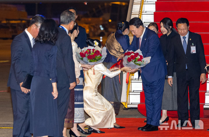 [비엔티안=뉴시스] 최진석 기자 = 아세안(ASEAN·동남아시아국가연합) 정상회의 참석차 라오스를 방문한 윤석열 대통령과 부인 김건희 여사가 9일(현지시각) 비엔티안 왓타이 국제공항에 도착해 1호기에서 내려 환영 인사로부터 꽃다발을 받고 있다. 2024.10.09. myjs@newsis.com