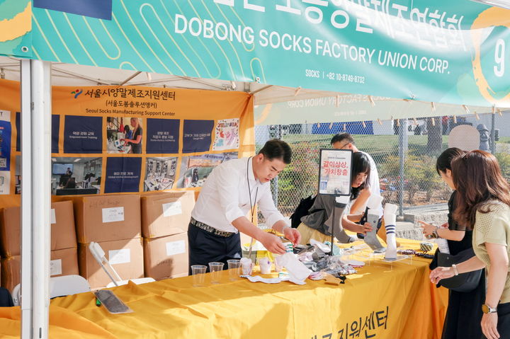 [서울=뉴시스]오언석 도봉구청장(가운데)이 LA한인축제에서 도봉구 양말 제품을 홍보하고 있다. 2024.10.10. (사진=도봉구 제공) *재판매 및 DB 금지