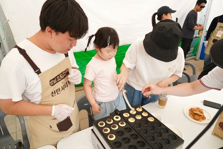 [천안=뉴시스] 12일 천안종합운동장에서 열린 '2024 빵빵데이 천안 축제장'에서 한 아동이 빵 만들기 체험 행사에 참여하고 있다. (사진=천안시 제공) *재판매 및 DB 금지