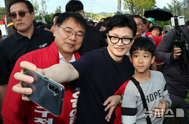 [부산=뉴시스] 하경민 기자 = 한동훈 국민의힘 대표가 12일 부산 금정구 도시철도 1호선 노포역을 출발해 온천장역까지 도보로 이동하던 중 시민들과 기념사진을 찍으며 윤일현 금정구청장 보궐선거 후보의 지지를 호소하고 있다. 2024.10.12. yulnetphoto@newsis.com