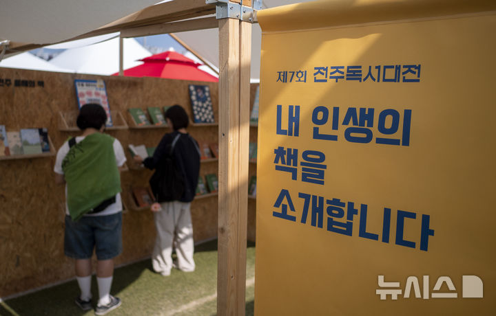 [전주=뉴시스] 강경호 기자 = 12일 전북 전주시 전주종합경기장 일원에서 개최된 '2024 전주독서대전'을 찾은 방문객들이 행사장 야외마당에 전시된 '전주 올해의 책' 전시물을 살펴보고 있다. 2024.10.12. lukekang@newsis.com