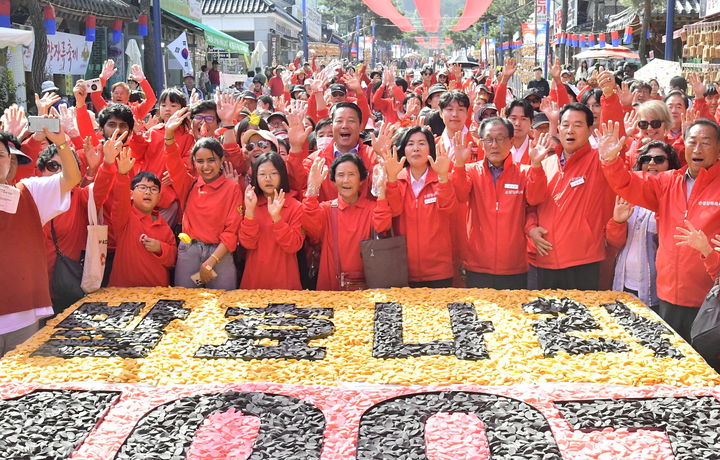 [순창=뉴시스] 김종효 기자 = 지난 12일 '제19회 순창장류축제', 최영일 순창군수와 참여자들이 가래떡 조각을 이용해 '발효나라 1997'을 완성한 뒤 환호하고 있다. '발효나라 1997'은 순창고추장민속마을이 생겨난 해를 기념하는 퍼포먼스다. (사진=순창군청 제공) 2024.10.13. photo@newsis.com *재판매 및 DB 금지