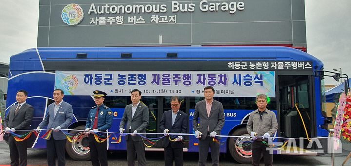 [하동=뉴시스]14일 경남 하동군 하동시외버스터미널 공용주차장에서 열린 경남 최초의 '농촌형 자율주행버스 시승식'에 참석한 하동군수, 도의원, 군의원, 하동경찰서장 등이 기념촬영하고 있다.(사진=경남도 제공) 2024.10.14. photo@newsis.com