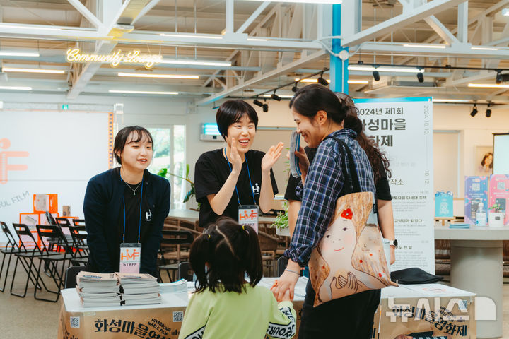 [화성=뉴시스] 화성마을영화제 폐막 현장. 한 엄마가 아이의 손을 잡고 영화상영관인 화성시 생활문화창작소를 찾았다. 영화제 관계자가 밝은 모습으로 모녀를 맞이하고 있다.(사진=화성시 제공)2024.10.14.photo@newsis.com