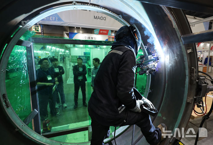 [고양=뉴시스] 전진환 기자 = 지난해 10월 15일 경기도 고양시 킨텍스에서 열린 2024 국제 공구 및 스마트 용접 자동화전에서 한 업체 부스에서 관람객들이 챔버 용접 시스템 시연을 지켜보고 있다 2024.10.15. amin2@newsis.com
