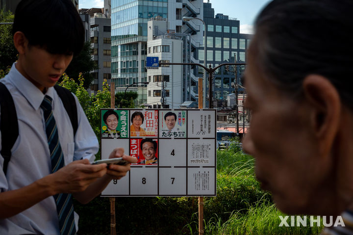 [도쿄=신화/뉴시스]일본 시민들이 지난해 10월 15일 일본 도쿄에서 진행 중인 중의원 선거 캠페인을 위한 게시판을 지나가고 있다. 2024.10.22.